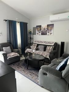 a living room with couches and a coffee table at Comfort Rest - Whim in Old Harbour