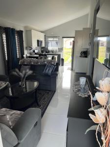 a living room with couches and tables and a kitchen at Comfort Rest - Whim in Old Harbour +15 photos