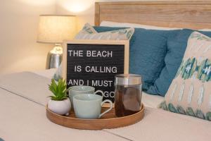 a tray with a sign on top of a bed at Beach Getaway - Pool & 2 King Beds in Sebastian