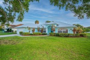 a large white house with a green lawn at Beach Getaway - Pool & 2 King Beds in Sebastian