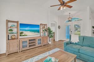 a living room with a blue couch and a tv at Beach Getaway - Pool & 2 King Beds in Sebastian +39 photos