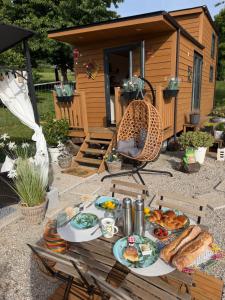 a table with food on it in front of a cabin at Tiny House Beija-Flor in Challex