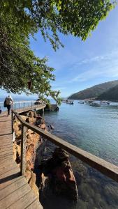 a wooden boardwalk next to a body of water at Casa Recanto in Angra dos Reis