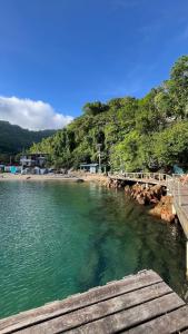 a bridge over the water next to a beach at Casa Recanto in Angra dos Reis