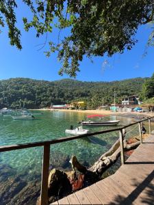 a boat on the water next to a beach at Casa Recanto in Angra dos Reis