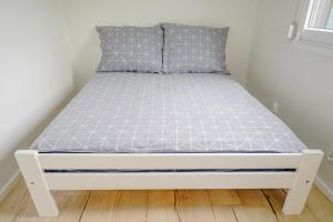 a bed in a room with a white bed frame at Domek w Suchaczu in Suchacz