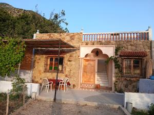 a house with a porch and a table and chairs at Smart House in Chefchaouen +8 photos