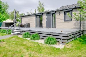 a modular home with a deck and grass at Domek w Suchaczu in Suchacz