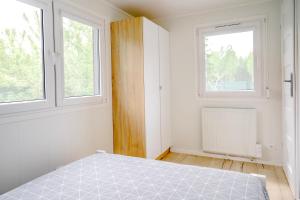 a white bedroom with a bed and two windows at Domek w Suchaczu in Suchacz +3 photos