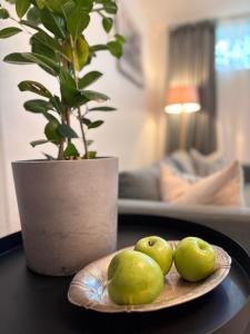 a plate of green pears on a table with a plant at Sundsvall By M - Basement Studio in Sundsvall +23 photos