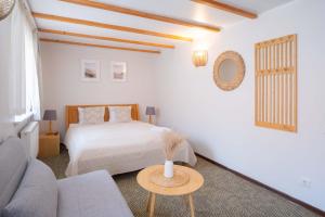 a white bedroom with a bed and a table at Laguna Self Check-in in Nida