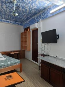 ein Zimmer mit einem Bett und einem Flachbildfernseher in der Unterkunft Claudia STUDIO in Basse-Terre