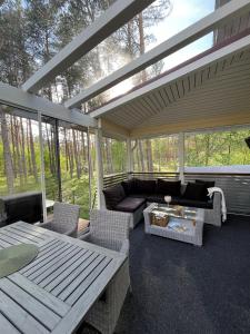 a screened in porch with a couch and a table at Kurjenpesä in Kalajoki +8 photos