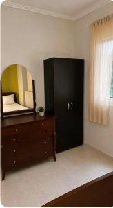 a bedroom with a dresser and a mirror on the wall at HOUSE WITH GARDEN Netflix in Néa Kerasiá +4 photos