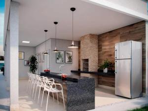 a kitchen with a white refrigerator and white stools at Apartamento completo em Ponta de Campina, 2 quartos, piscina, academia e Wi-Fi in Cabedelo