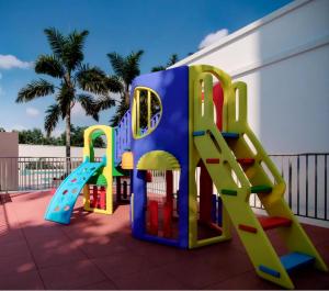 a playground with a slide and a play set at Apartamento completo em Ponta de Campina, 2 quartos, piscina, academia e Wi-Fi in Cabedelo