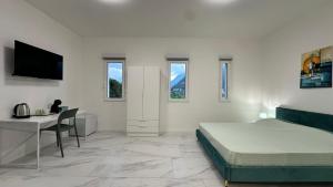 a bedroom with a bed and a desk and a television at Panorama Terrace - Como Lake in Como