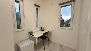 a white room with a desk and two windows at Panorama Terrace - Como Lake in Como