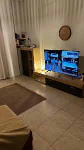 a living room with a large flat screen tv at HOUSE WITH GARDEN Netflix in Néa Kerasiá