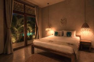a bedroom with a large bed and a window at The Garten Living in Paje