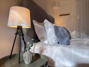 a bed with pillows and a lamp on a table at Sundsvall By M - Basement Studio in Sundsvall