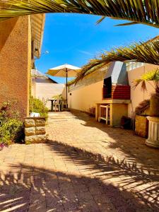 a brick walkway with an umbrella and a building at Mathéro in Saint-Pair-sur-Mer