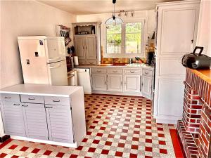 a kitchen with white appliances and a checkered floor at Mathéro in Saint-Pair-sur-Mer +4 photos