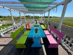 a deck with colorful tables and chairs on it at Guest house FantasY in Tyulenovo +42 photos