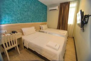 Postel nebo postele na pokoji v ubytování Pantai Inn Kota Kinabalu