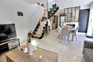 a living room with a table and a spiral staircase at Ty feuteun in Lanvellec