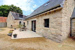 a stone building with a patio in front of it at Ty feuteun in Lanvellec