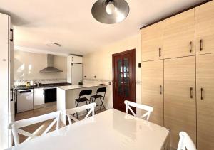 a kitchen with a white table and chairs in it at Xivares playa in Carrió