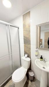 a white bathroom with a toilet and a sink at Casa Mama Hotel in Manizales +50 photos