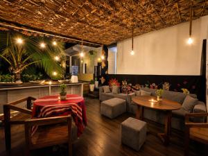 a room with two tables and a couch and chairs at Casa Moon Trincomalee Beach House in Trincomalee