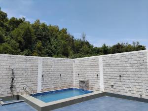a brick wall with a swimming pool in it at Casa Oceanus - Pool Facing Room - Ganpatipule in Nevra