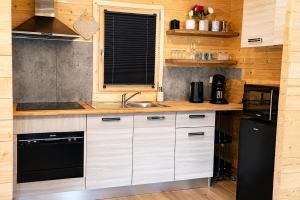 a kitchen with white cabinets and a black appliance at Bosquet Secret in Froid-Chapelle