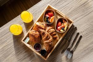 a tray of food with croissants and fruit on a table at Bosquet Secret in Froid-Chapelle +15 photos