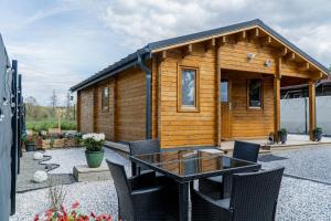 a small wooden cabin with a table and chairs at Bosquet Secret in Froid-Chapelle