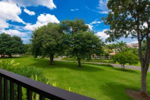 a view from a balcony of a park with trees and grass at Chic Minimalist Condo with Swimming Pool, Hot Tub, and Beach Club Access in Coco