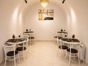 a row of tables in a room with white chairs at Central City Department Hotel in Baku