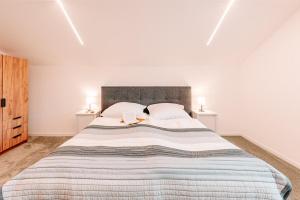 a white bedroom with a large bed with two lamps at Komfortable Familienwohnung in Moosham