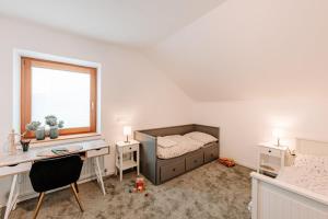 a bedroom with a bed and a desk and a window at Komfortable Familienwohnung in Moosham
