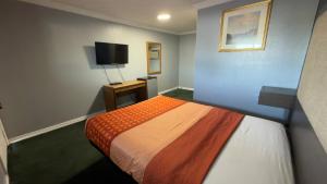 a room with a bed and a flat screen tv at Ada Inn & Suites in Ada