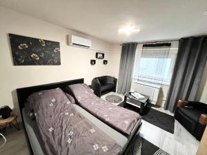 a bedroom with a bed and a chair in a room at Csillag Vendégház in Debrecen
