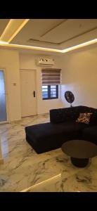 a living room with a couch and a table at WHITE CASTLE Apartments in Hausa