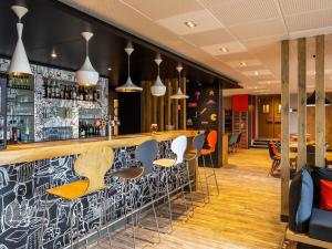 a bar with a black and white wall at ibis Saint-Malo Madeleine in Saint Malo