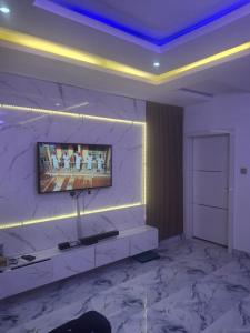 a living room with a tv on a marble wall at WHITE CASTLE Apartments in Hausa