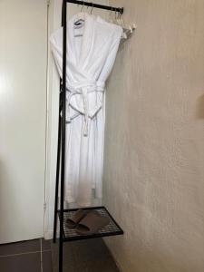 a rack with a white robe on a wall at Sundsvall By M - Basement Studio in Sundsvall