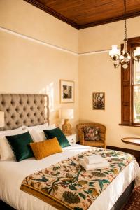 a bedroom with a large bed with green pillows at Albert Manor guest house in Ladismith