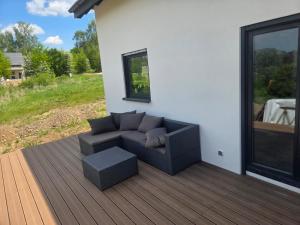 a couch sitting on a deck next to a window at Domek na Sowiej in Kłodzko